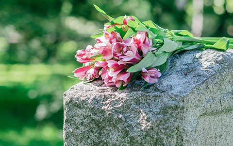 Blumenstrauß auf Grabstein nach Bestattung im Land Salzburg